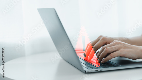 Businessman or programmer, developer using computer laptop with triangle caution warning sign for notification error and maintenance concept. Virus detected warning, Cybercrime protection. 