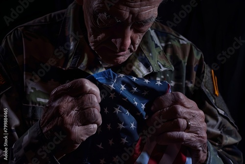 Old soldier folding American flag. Patriotic symbol on dark background.