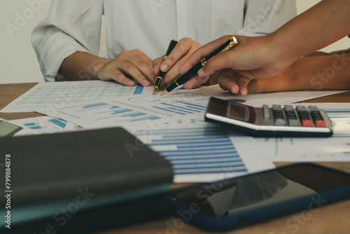 In an office, a woman and a man work together at a desk, using teamwork and communication to succeed in their business meeting.