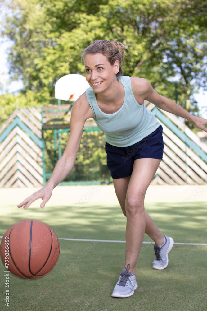 happy woman in jump throwing the basket ball