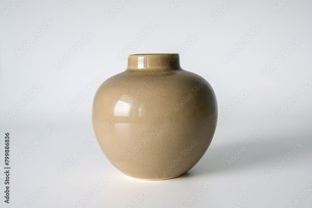 A small vase with a brown color sits on a white background. The vase is empty and has a simple design. Concept of calmness and simplicity A small vase with a brown color sits on a white background. The vase is empty and has a simple design. Concept of calmness and simplicity