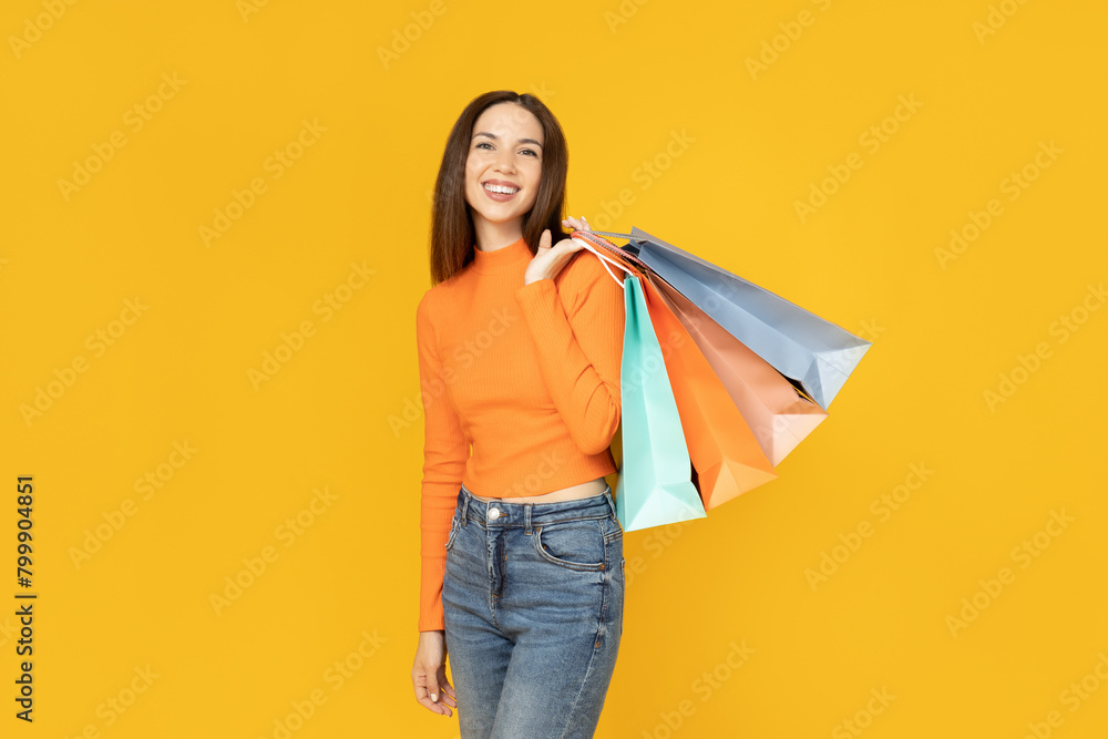 Young girl with shopping bags on a yellow background. Young girl with shopping bags on a yellow background.