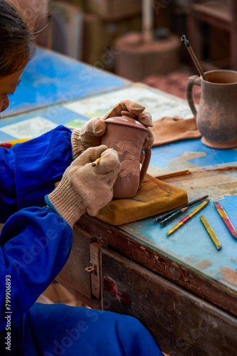 A craftsman makes porcelain in a traditional Chinese porcelain factory © Steve
