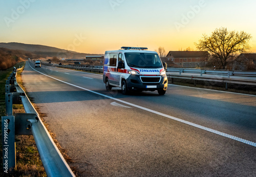 Ambulance van on highway at sunset. Ambulance car responding to the scene of an emergency.