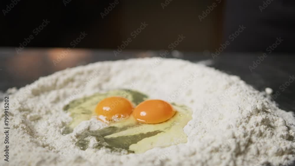 Hand Of Chef Cracking Eggs Into Flour For Dough Pasta Tagliatelle Hand Of Chef Cracking Eggs Into Flour For Dough Pasta Tagliatelle