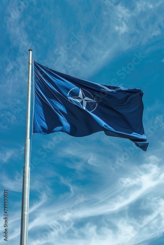 Blue flag with nato symbol flying in the sky
