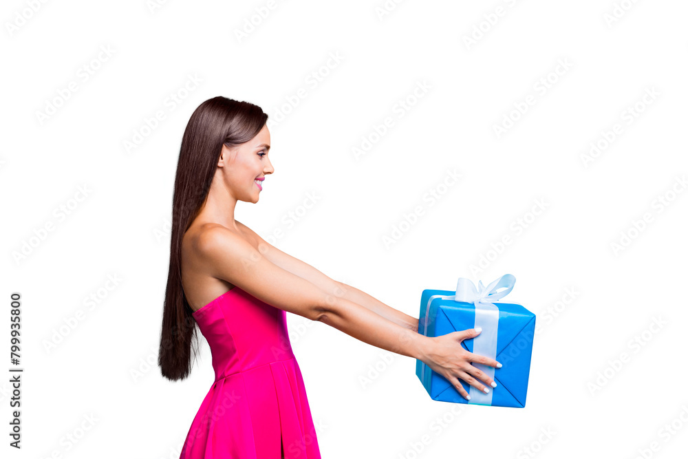 Side profile view of young straight-haired sweet tender brunette smiling girl with long hair, wearing pink dress, giving blue box with white ribbon. Isolated over bright vivid turquoise background Side profile view of young straight-haired sweet tender brunette smiling girl with long hair, wearing pink dress, giving blue box with white ribbon. Isolated over bright vivid turquoise background