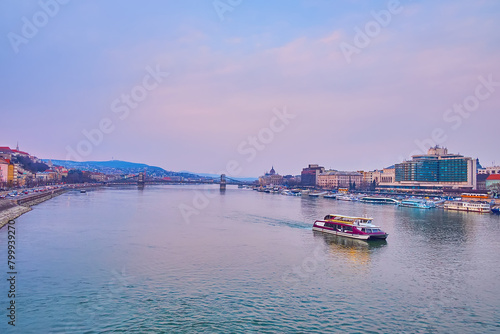 The tourist ferry on Danube against the Szechenyi Chain Bridge, Budapest, Hungary