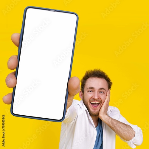 Product placement mobile app advertisement great offer young happy man holding smartphone showing white empty screen
