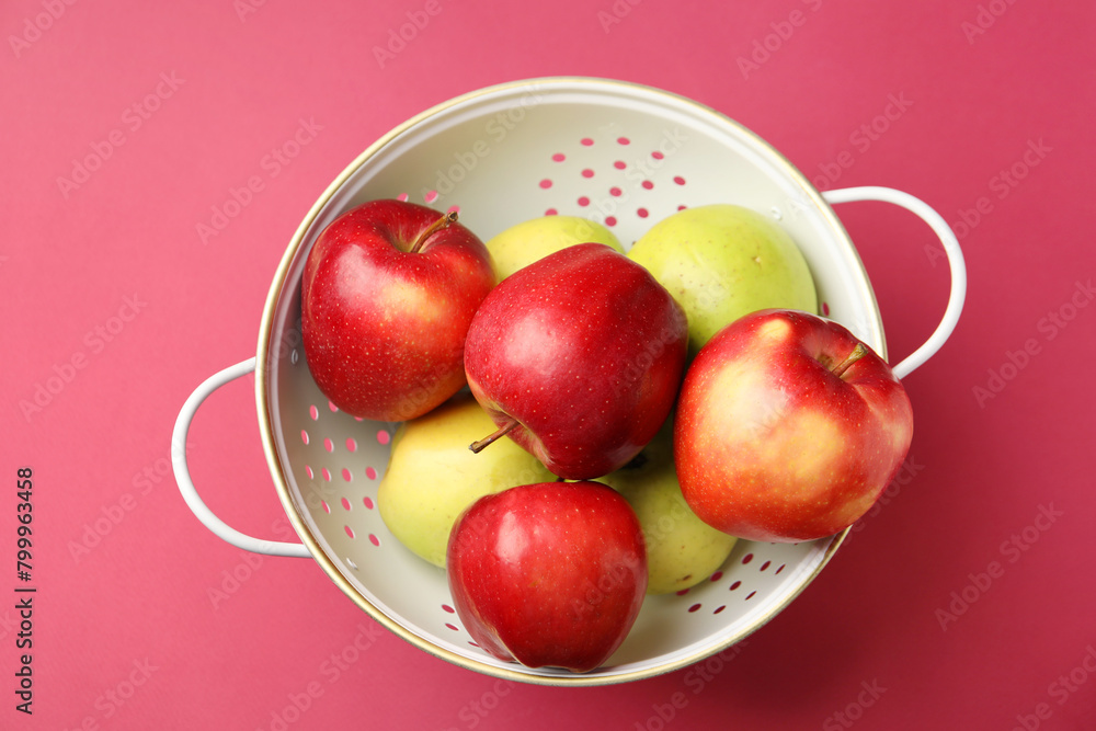 Colander with fresh apples on pink table, top view Colander with fresh apples on pink table, top view