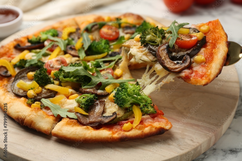 Taking piece of delicious vegetarian pizza at table, closeup Taking piece of delicious vegetarian pizza at table, closeup