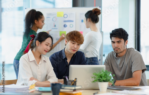 Asian group of people working with documents have financial or marketing charts on a board room table at a business presentation or seminar.