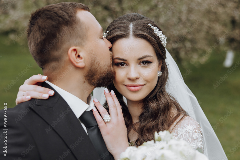 A bride and groom are kissing each other's cheeks