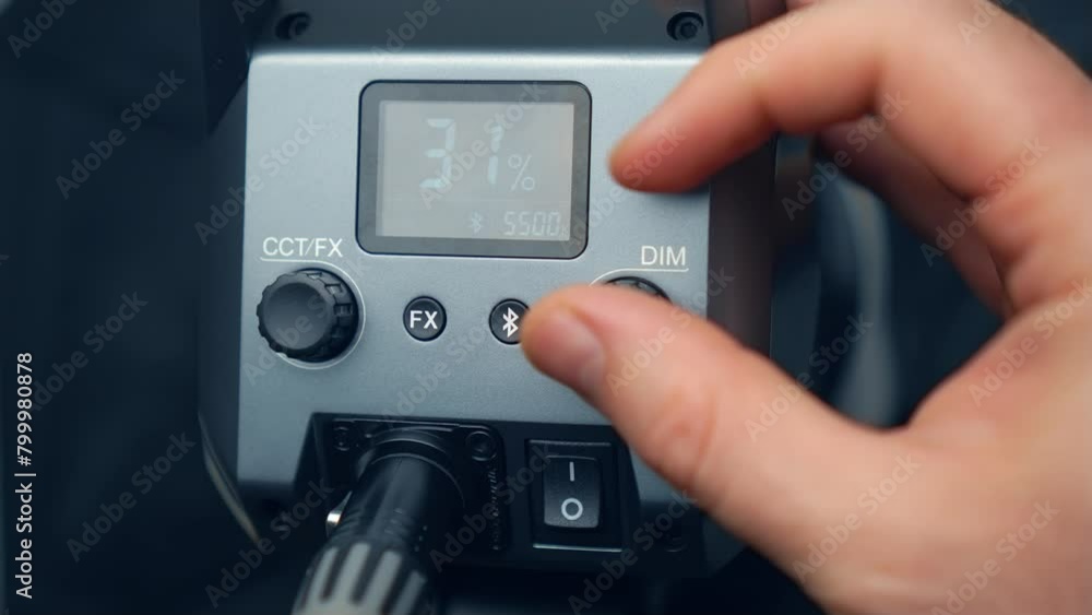 Man fingers twist toggle switch close up, adjusting light temperature on LED video lights for video shooting. Equipment for studio video shooting, news media and film production Man fingers twist toggle switch close up, adjusting light temperature on LED video lights for video shooting. Equipment for studio video shooting, news media and film production