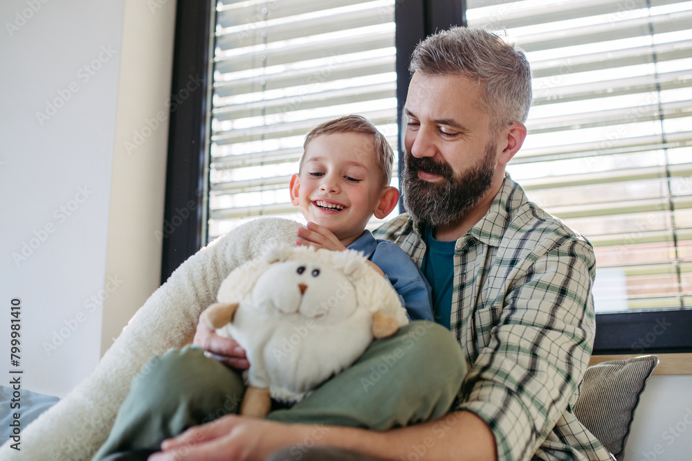 Portrait of smiling boy with father, holding his favourite plush toy. Portrait of smiling boy with father, holding his favourite plush toy.