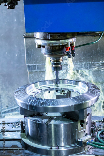 cnc. high precision CNC turning machine throwing coolant liquid on metal component in shaping forming process by computer numerical control automation milling workpiece using a rotating cutting tool.
