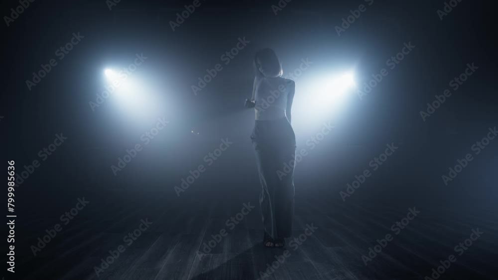 Young woman dancing in smoky studio. Silhouette dancer woman performing dance figures in fog. Nightlife. Talented woman dancing. 4K, UHD Young woman dancing in smoky studio. Silhouette dancer woman performing dance figures in fog. Nightlife. Talented woman dancing. 4K, UHD