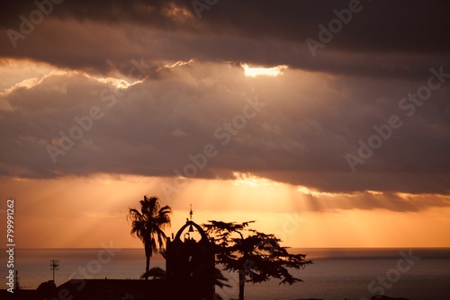 Rays of light emerge from behind storm clouds at sunset over the Mediterranean Sea. 