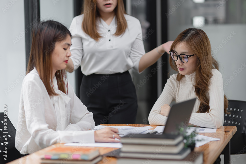 Group of young asian businesswoman working and brainstorming in workshop and analyzing marketing reports startup project infographics in the office. Group of young asian businesswoman working and brainstorming in workshop and analyzing marketing reports startup project infographics in the office.