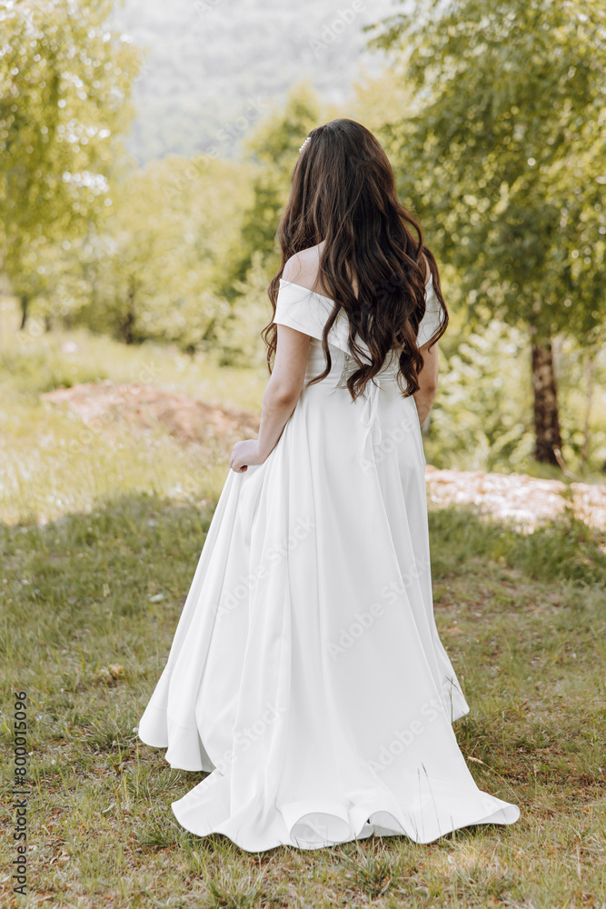 A woman in a white dress is standing in a field