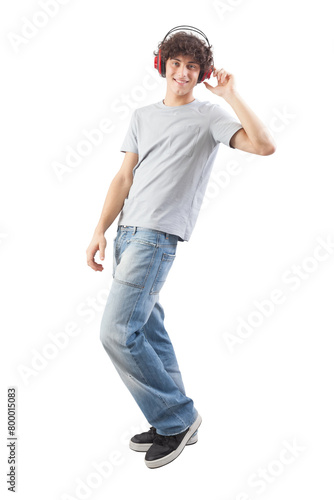 Young handsome smiling man wearing headphones to listen to music and dancing while looking into the camera, full body isolated against a white background