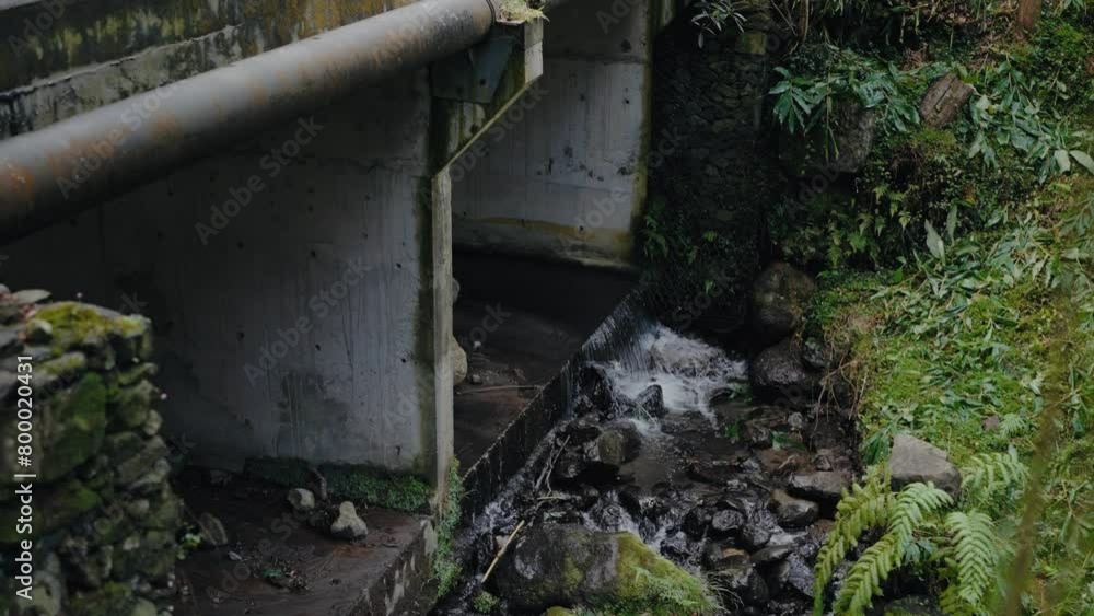 Old bridge, iron pipeline and water flowing outdoors. Water stream on street Old bridge, iron pipeline and water flowing outdoors. Water stream on street