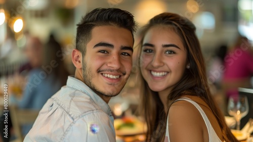 Young couple smiling together in a restaurant setting. © iuricazac