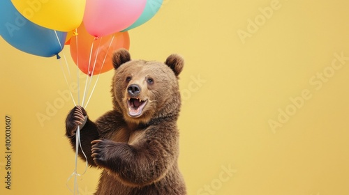 Cheerful bear clutching colorful birthday balloons, joy radiating against a soft yellow background
