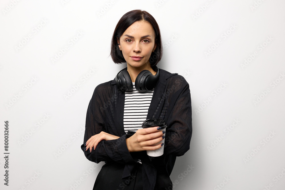 Stylish young woman in a fashionable look holding a cup of coffee on a white background with copy space Stylish young woman in a fashionable look holding a cup of coffee on a white background with copy space