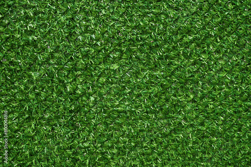 Texture of artificial green grass fencing panel as background © Bits and Splits