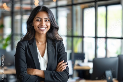 Young confident smiling Indian business woman leader, successful entrepreneur, professional company executive ceo manager, wearing suit standing in office with arms crossed