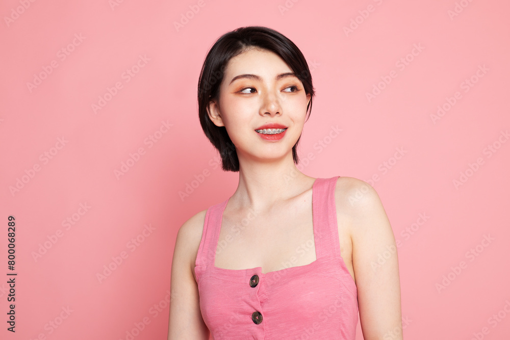 Smiling young woman against pink background Smiling young woman against pink background