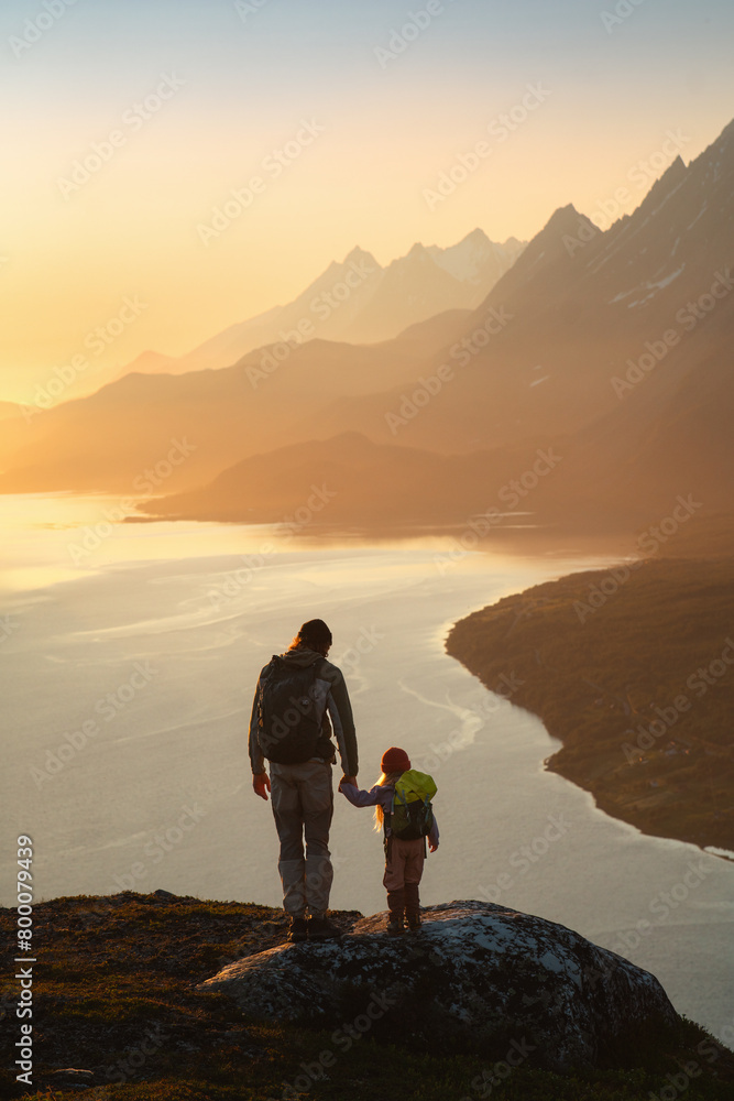 Family father and child hiking in mountains traveling together exploring Norway adventure healthy lifestyle outdoor active summer vacations dad with daughter with backpack enjoying sunset fjord view Family father and child hiking in mountains traveling together exploring Norway adventure healthy lifestyle outdoor active summer vacations dad with daughter with backpack enjoying sunset fjord view
