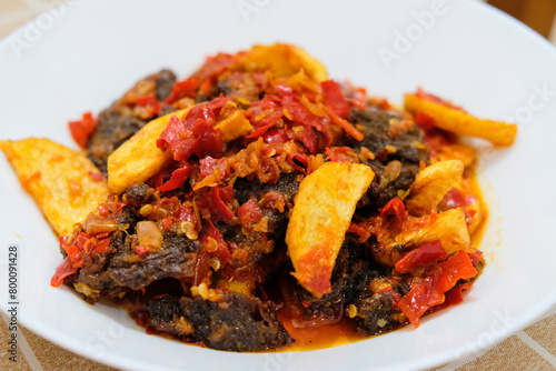 Selective focus of dendeng balado, a traditional cuisine from West Sumatera, Indonesia. It is made from slice of beef with spicy sauce called sambal.