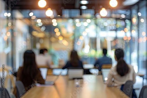 Blurred image of professionals in a business meeting within a contemporary office space, emphasizing movement and busy corporate life.