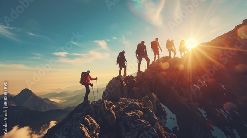 Big group of people having fun in success pose with raised arms on mountain top against sunset lakes and mountains. Travel, adventure or expedition concept photo