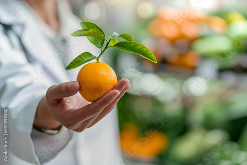 Doctor holding an orange kumquat with leaves, symbolizing fresh produce and healthy diets photo