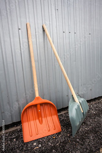 Two large shovels are waiting for the start of work on the gravel near the metal trailer. An image for your creative design about work and construction.