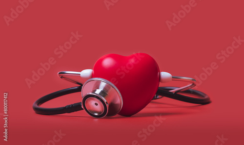 Red heart shape  exercise ball with doctor physician's stethoscope on red background, hospital life insurance concept, world heart health day. doctor day, world hypertension day,