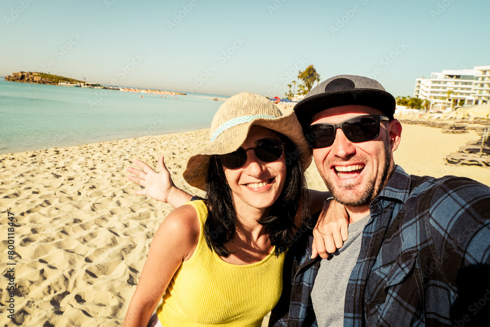 Happy traveling couple making selfie sea background. Summer beach holidays. Romantic mood. Stylish sunglasses. Happy laughing emotional faces hipster multiracial. Cyprus holiday Happy traveling couple making selfie sea background. Summer beach holidays. Romantic mood. Stylish sunglasses. Happy laughing emotional faces hipster multiracial. Cyprus holiday