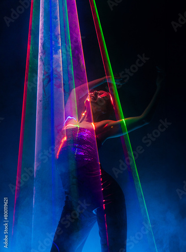 Beautiful woman dancing under colorful illumination, laser light, neon party night club. Performance, projection mapping. Interactive exposition installation.