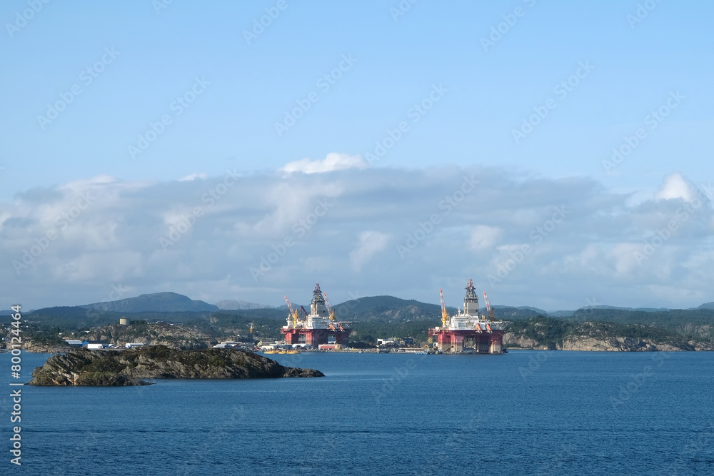 Sea coast with gas or oil production platforms against the backdrop of picturesque highlands