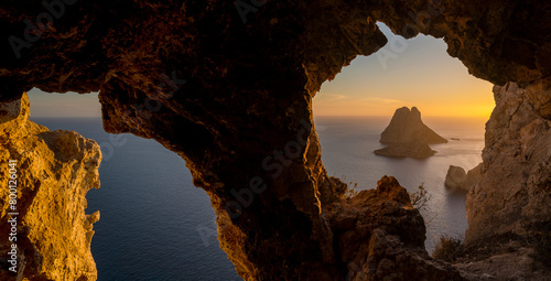 Es Vedra island sunset panorama viewed from a cave rock hole, Sant Josep de Sa Talaia, Ibiza, Balearic Islands, Spain
 photo