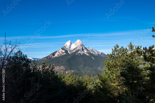 Verdant forests frame the rugged Pedraforca peak in Catalonia, Spain, showcasing the mountain's natural splendor and greenery photo