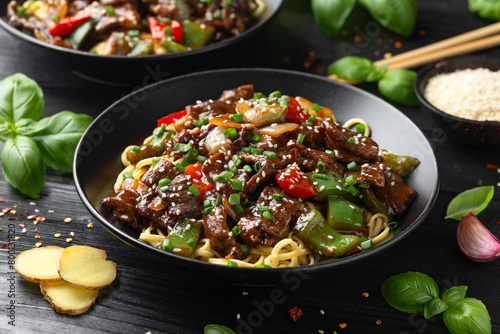 Stir fried beef in black bean sauce with vegetables and noodles. Take away food photo