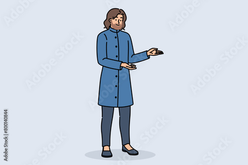 Indian man with beard, dressed in blue traditional shervani clothing, points with hands to sides. Indian guy with mustache invites on trip to regions of india for study national culture