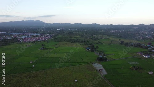 The aerial view of housing or cities surrounded by mountains and plantations looks very beautiful photo