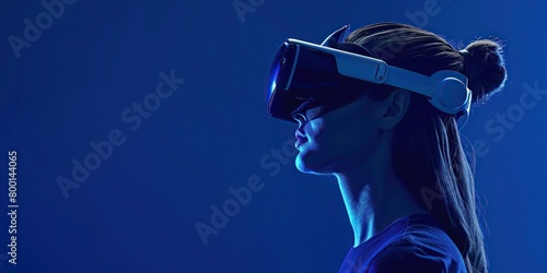 Elegant side view of a woman wearing VR glasses against a deep blue background. Beautiful stylish girl in VR goggles headset. Sleek futuristic banner for virtual reality game, application. Copy space