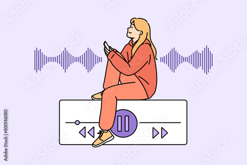 Teenage woman listens to music on phone, sitting near equalizer on buttons to control playlist. Music lover girl uses audio application on smartphone to play favorite songs or audio books