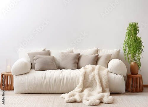 White sofa with grey pillows and sheepskin fur plaid. Scandinavian, hygge home interior design of modern living room.